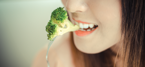 Woman eating Broccoli