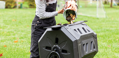 Person dumping a pale of food scraps into a compost bin