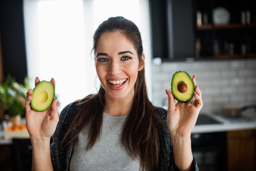 Smiling woman with avocado